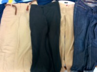 4 pairs of pants including a pair of jeans, a pair of cotton khakis, a pair of tan linen pants, and lightweight black pants.