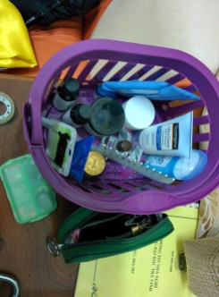2 (1 not pictured) bottles of sunscreen, 3 (2 not pictured) sticks of deodorant, 3 vials of essential oil: lavender, peppermint, tea tree oil, 1 pack of bobby pins, 1 jar of night cream, 1 comb, 1 jar of tigar balm, 1 case of jewelry, and 1 case of makeup including: moisturizer, travel brushes, eyelash curler, mascara, eye liner, eye shadow, lipstick